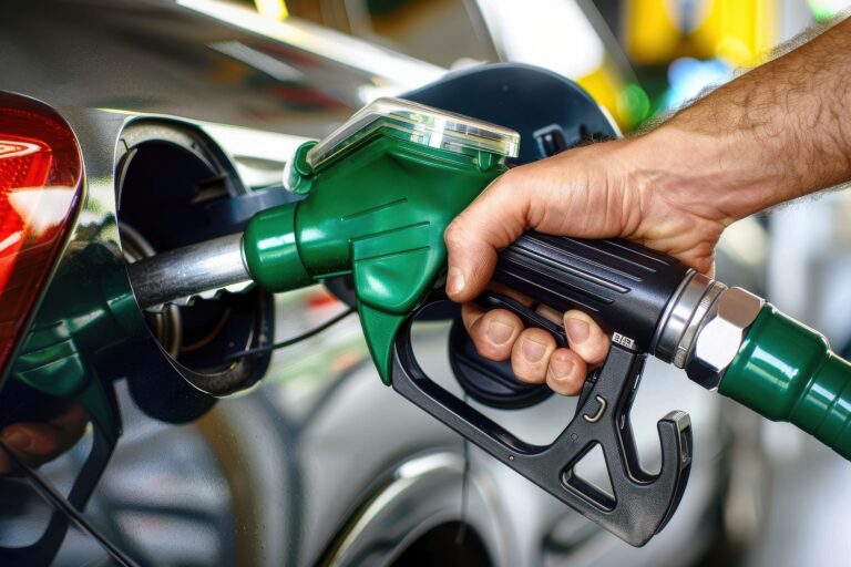 Man holds green fuel nozzle into gas tank car gas station man holds green fuel n