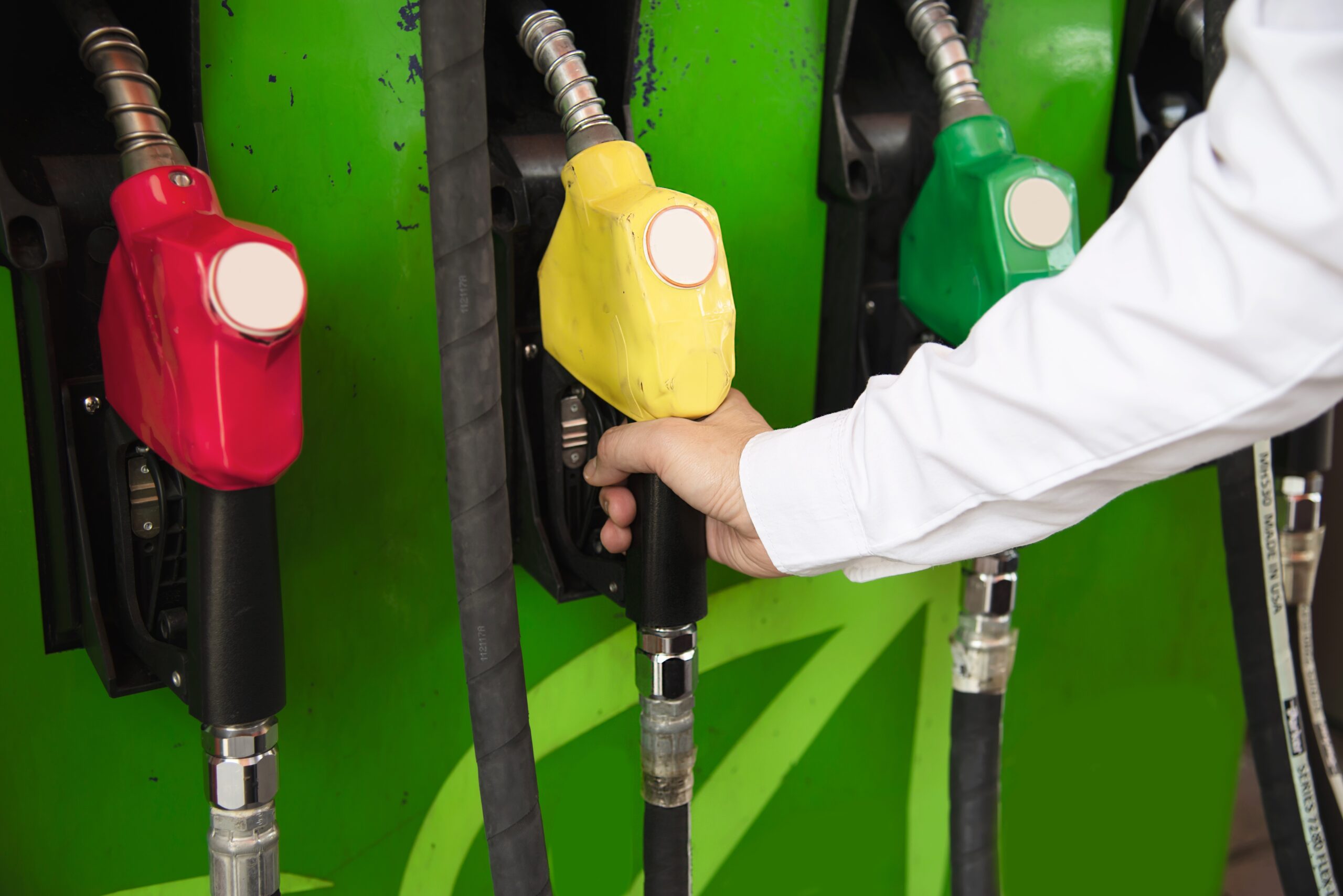 Man putting gasoline fuel into his car in a pump gas station